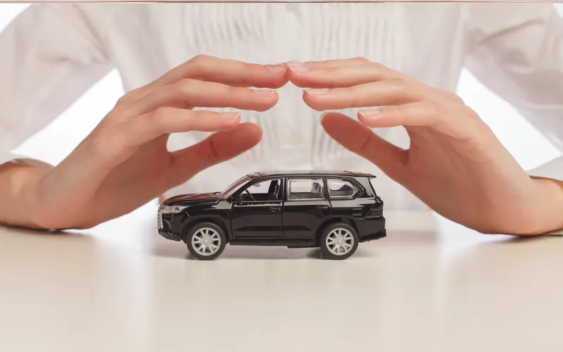 female hands toy car isolated white background insurance concept